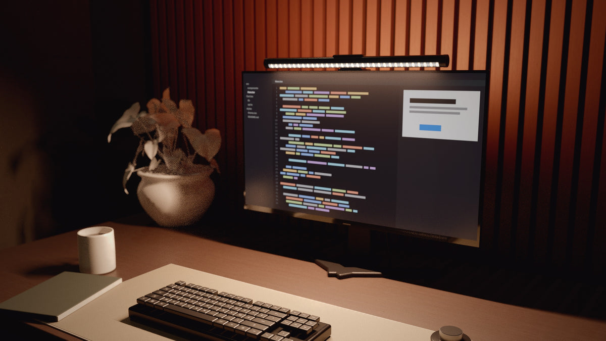Bureau en lumière chaude, code à l'écran, carnet et livres éclairés