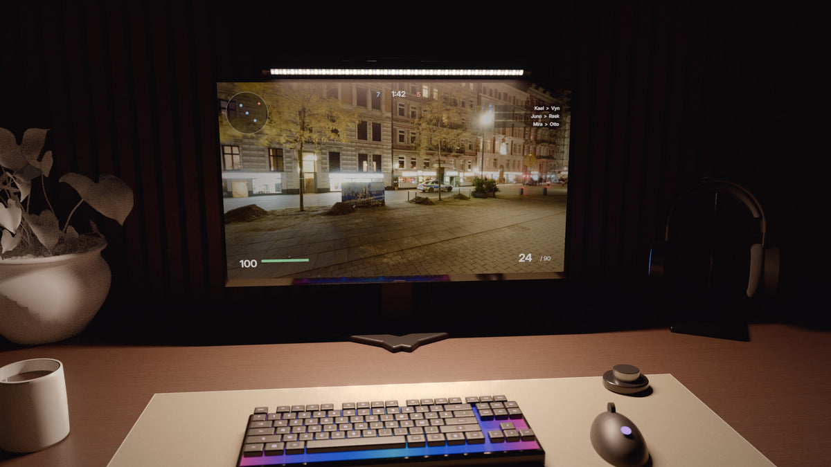 Bureau de nuit éclairé par HALVO One, clavier et tapis dans la lumière, écran net